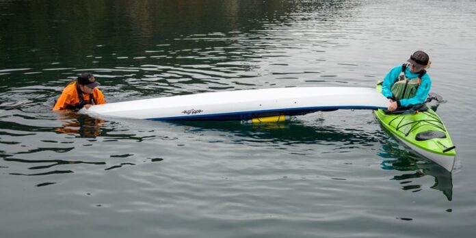 A frame grab from Sally Wallick’s video camera captures the scene as she saves the capsized kayaker from freezing. | Feature photo: Sally Wallick via Storyfull