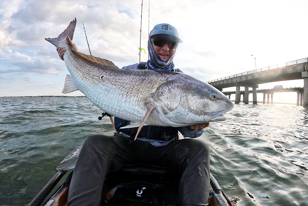 kayak angler holds up large red drum caught in Virginia