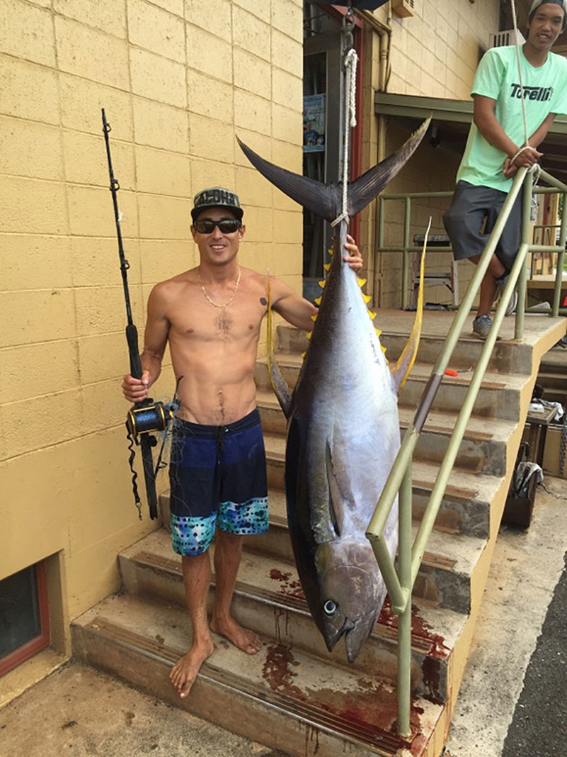 man poses with his yellowfin tuna catch
