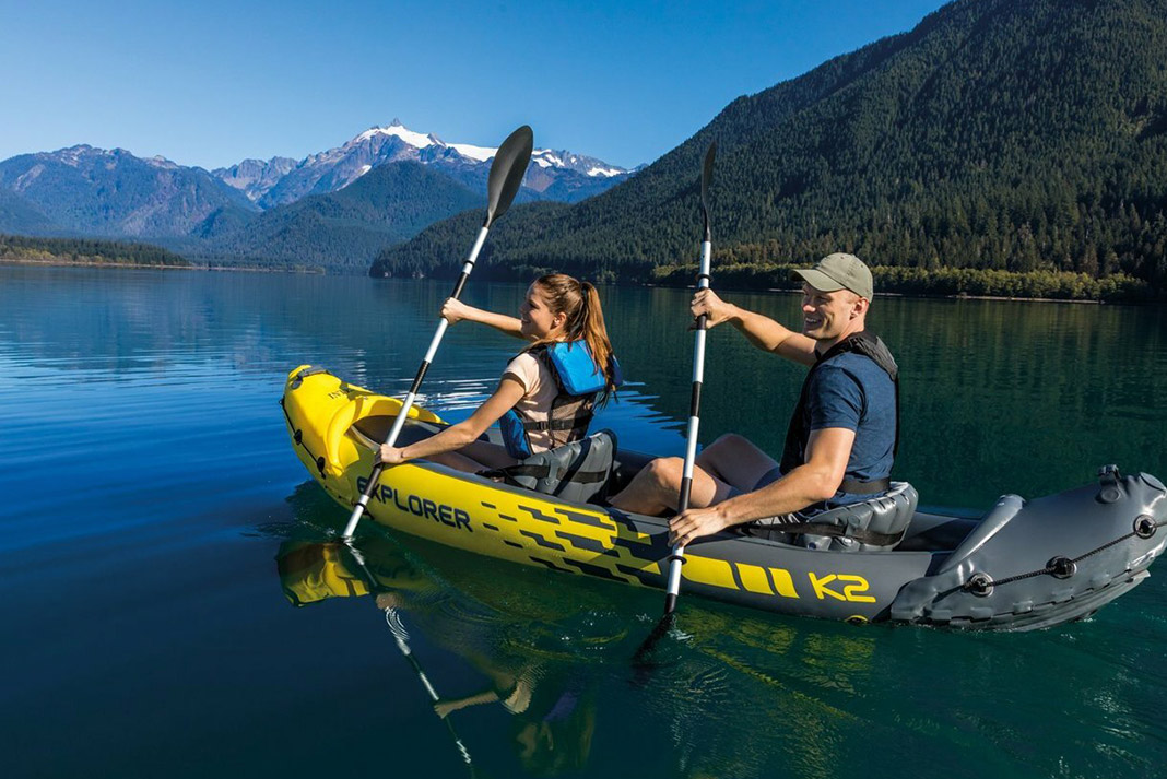 Two people paddle yellow and grey inflatable kayak