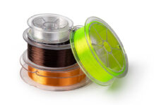 several rolls of fishing line stacked against a white background