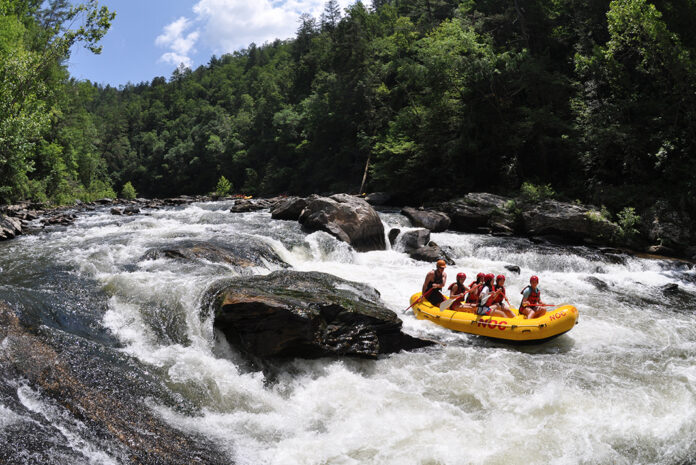Group going down a rapid in a yellow raft