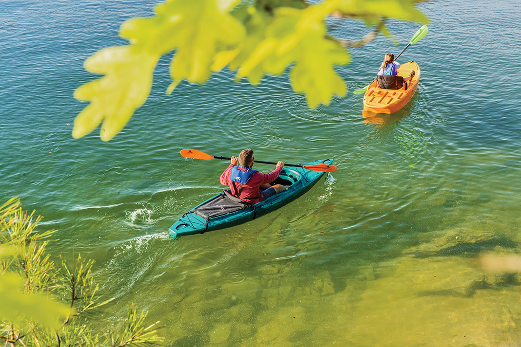 man and woman paddle in sit-inside and sit-on-top Ascend kayaks