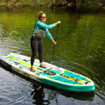 Inflatable SUP Review: BOTE Rackham Aero 12’4” woman stands and paddles the Bote Rackham Aero 12'4" inflatable SUP