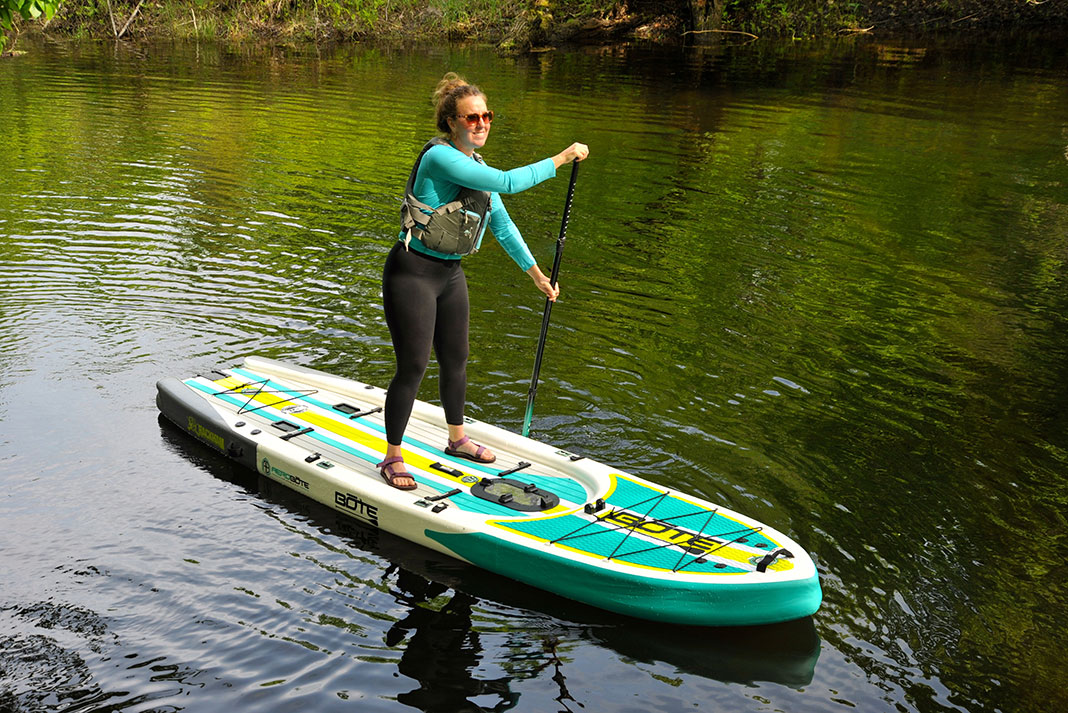 woman stands and paddles the Bote Rackham Aero 12'4" inflatable SUP