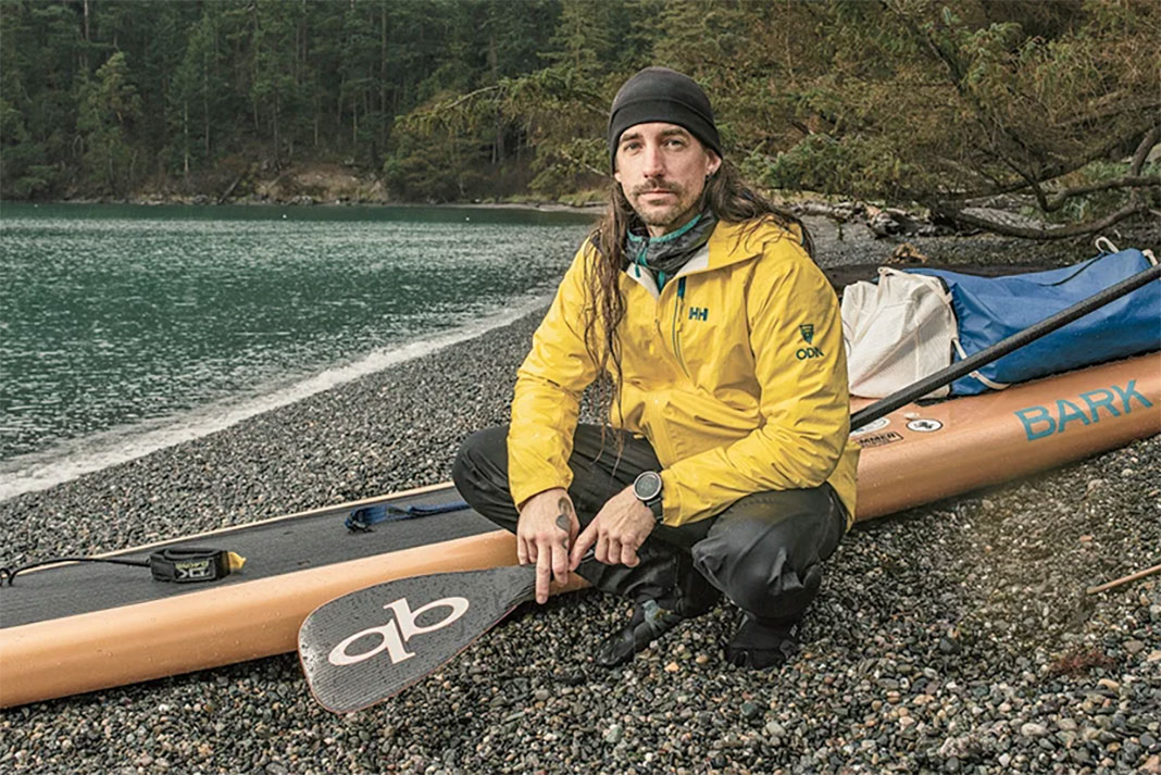 Karl Kruger poses beside his expedition paddleboard