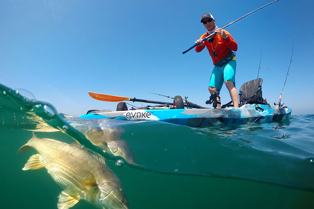 angler stands up and fishes from an Evoke standup fishing kayak