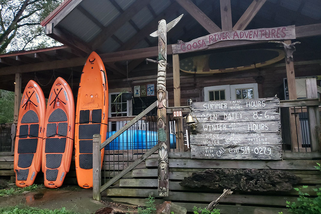 exterior photo of Coosa River Adventures outfitter with 3 orange paddleboards out front