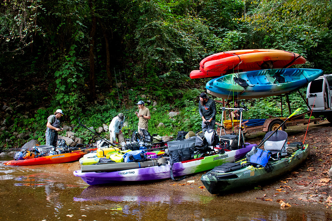 a group of kayak anglers unload colorful kayaks from a trailer at the Tallapoosa River