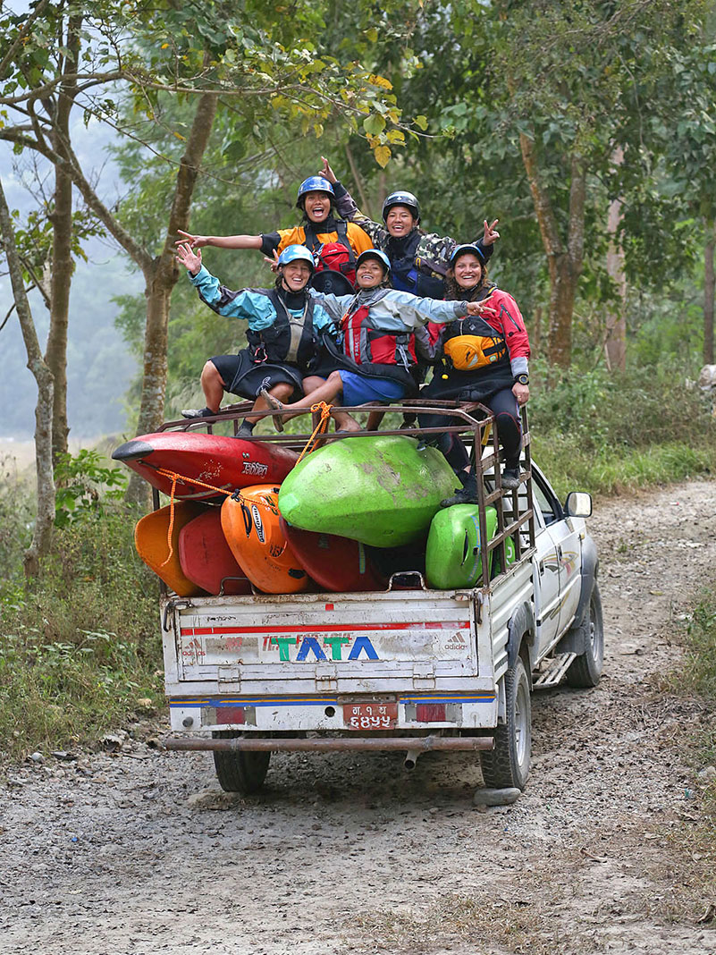 Himalayan Adventure Girls pose in paddling gear with their boats in a pickup truck