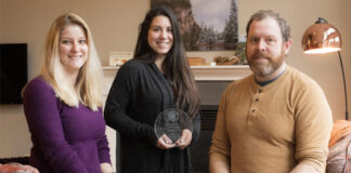 Three people pose with award