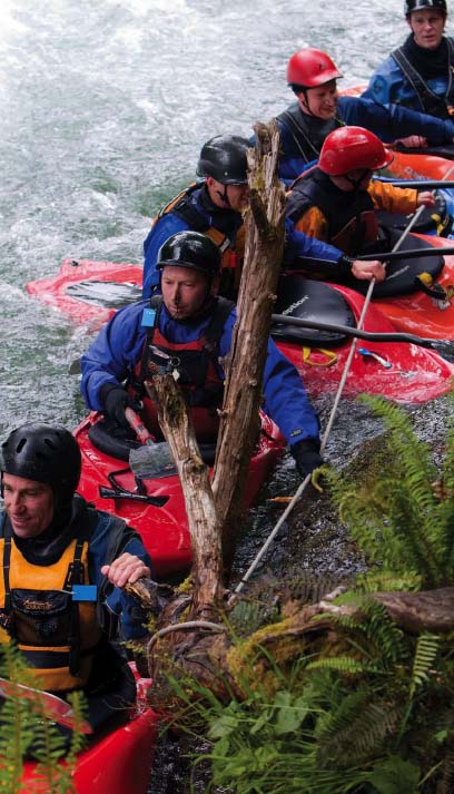 a group of men floating in freestyle kayaks, waiting for their turn to compete in a freestyle kayaking competition