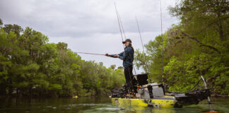 woman stands and casts from a fishing kayak equipped with a brushless motor