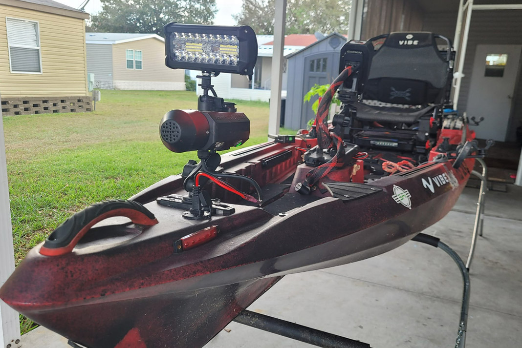 Red fishing kayak with light mounted to front