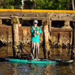 Hybrid Fishing SUP Review: Vibe Cubera 120 man stands and fishes from the Vibe Cubera 120 Hybrid fishing kayak paddleboard hybrid