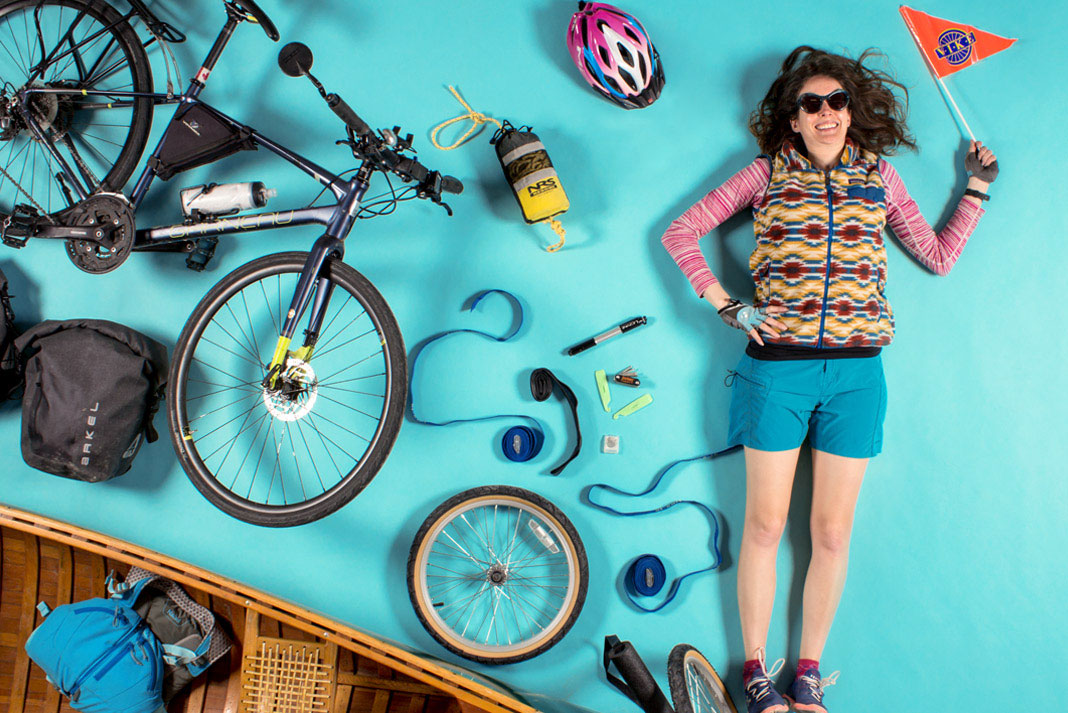 Woman surrounded by things needed for a bike canoe trailer rig