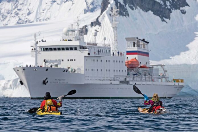 EWAN BLYTH AND SOPHIE BALLAGH APPROACH ONE OCEAN'S ROBUST EXPEDITION SHIP. | Photo: Nate Small