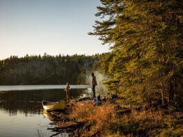 People fishing from shore with canoe pulled up