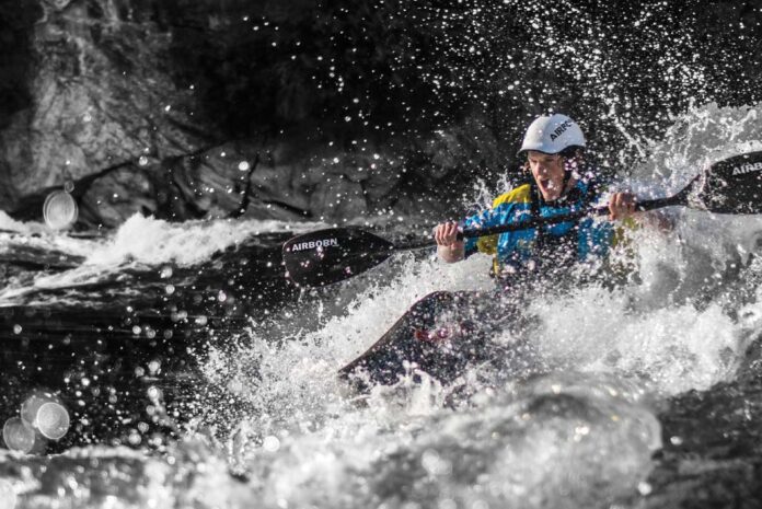 a young man paddles through whitewater on the Gatineau River
