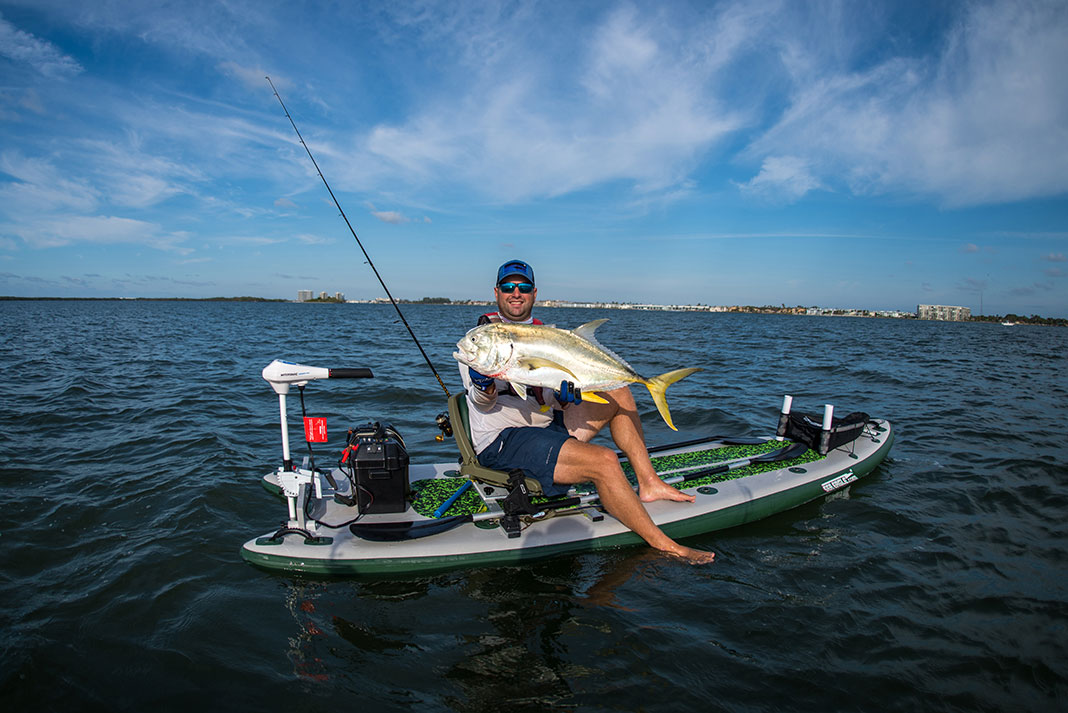 kayak angler holds up a big jack caught from a Sea Eagle boat