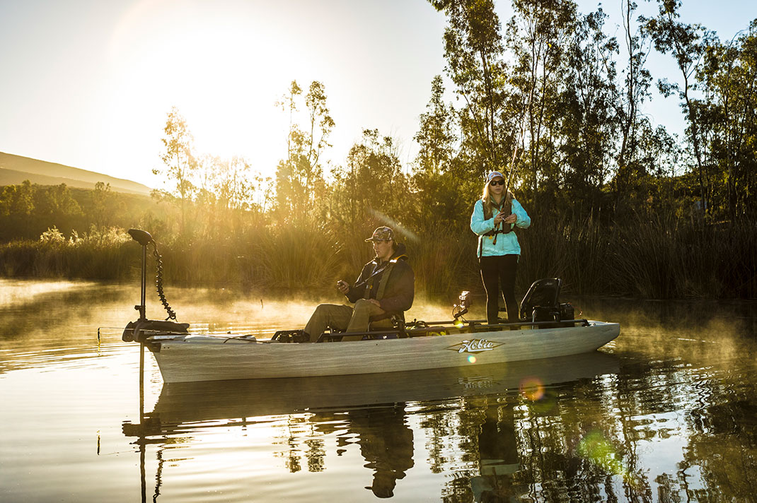 man and woman fish at dawn in a full-size Hobie fishing kayak