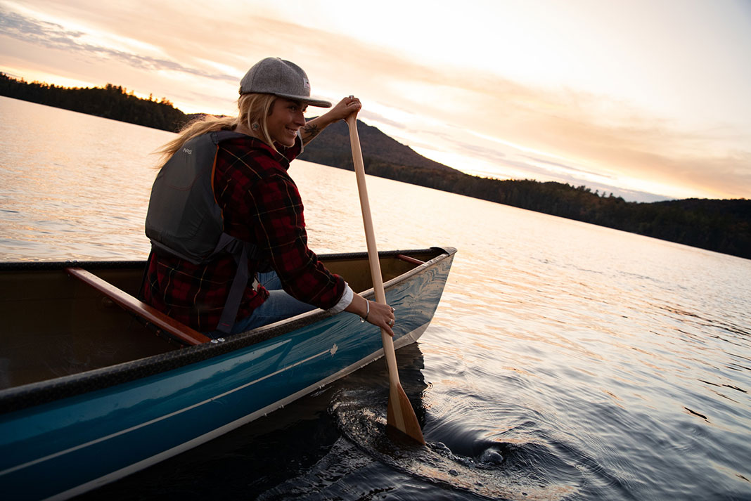 Woman paddling in bow of canoe