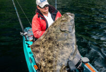 big game angler Adam Fisk holds up a huge halibut caught from a kayak in Alaska