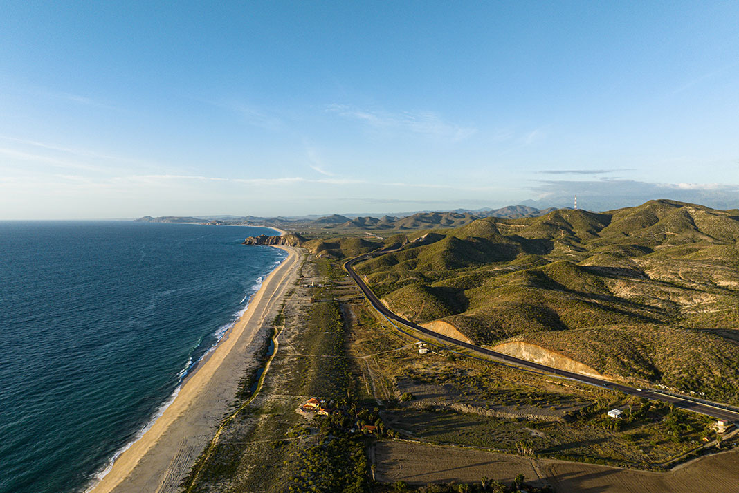 aerial photo looking along the Baja seaside highway with arid, rolling hills in behind