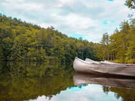 aluminum canoes sit on a calm lake