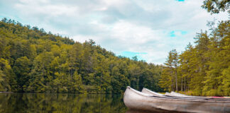 aluminum canoes sit on a calm lake