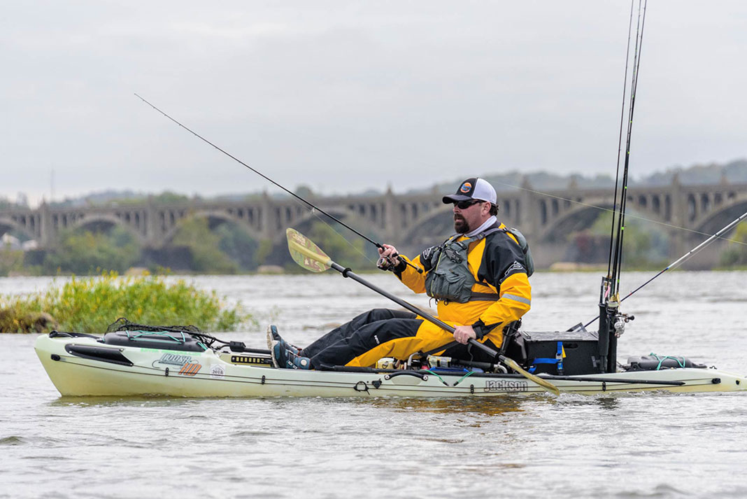 kayak angler fishes while wearing a drysuit from NRS