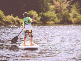 kid paddles on a standup paddleboard