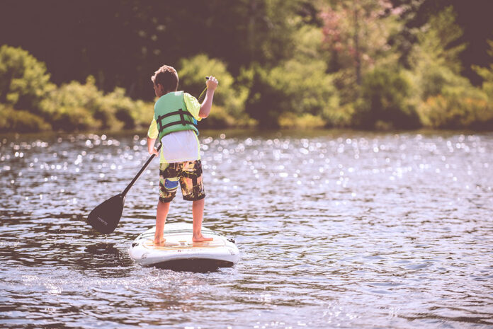 kid paddles on a standup paddleboard