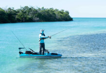 angler stands and fishes from Pelican Catch Pwr 100 kayak