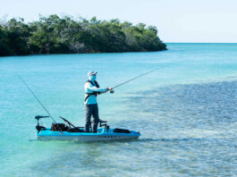 angler stands and fishes from Pelican Catch Pwr 100 kayak