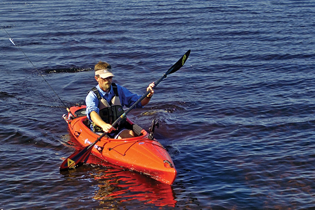 man demonstrates kayak power strokes