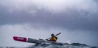 Bonnie Hancock paddles her surfski on choppy water under grey clouds while she circumnavigates Australia, setting two new world records