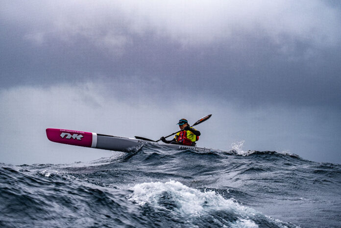 Bonnie Hancock paddles her surfski on choppy water under grey clouds while she circumnavigates Australia, setting two new world records