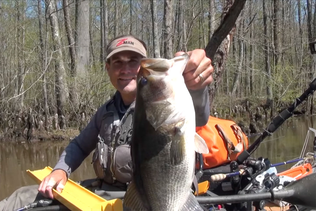 Jeff Little holds up a bass he caught after getting a trespassing ticket