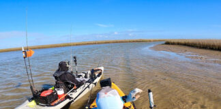 two kayak anglers struggle with mud while fishing low tide