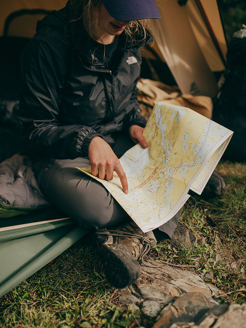 woman looks at a map while camping