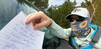 kayak angler pulls an "access denied" notice from his windshield after a day of tarpon fishing