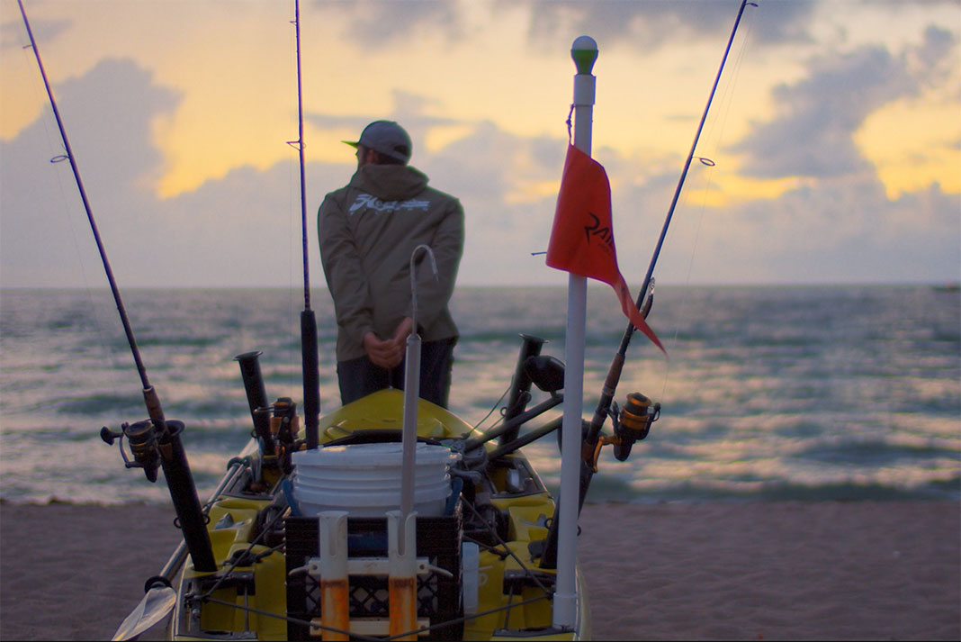 man prepares to launch fishing kayak at dawn in flotsam film