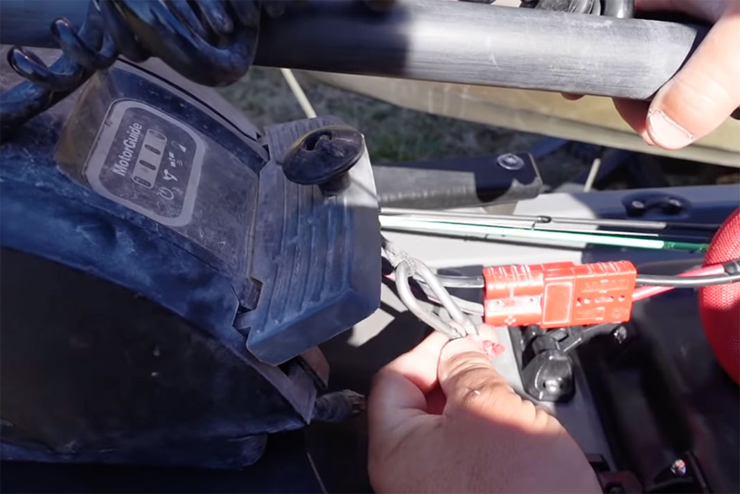 man shows off rigging for motor pedal on his fishing kayak
