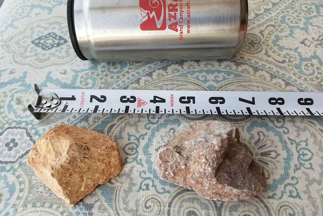 two rocks that fell in the flash flood are displayed beside a tape measure and a metal water bottle