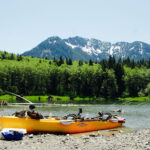 Everything You Need To Know About Buying A Hobie Hobie fishing kayak on a riverbank