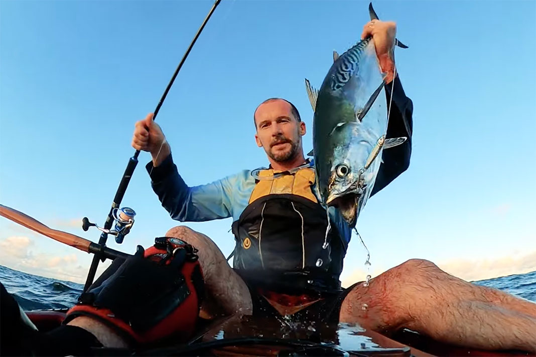 man holds up bluefin tuna caught by kayak