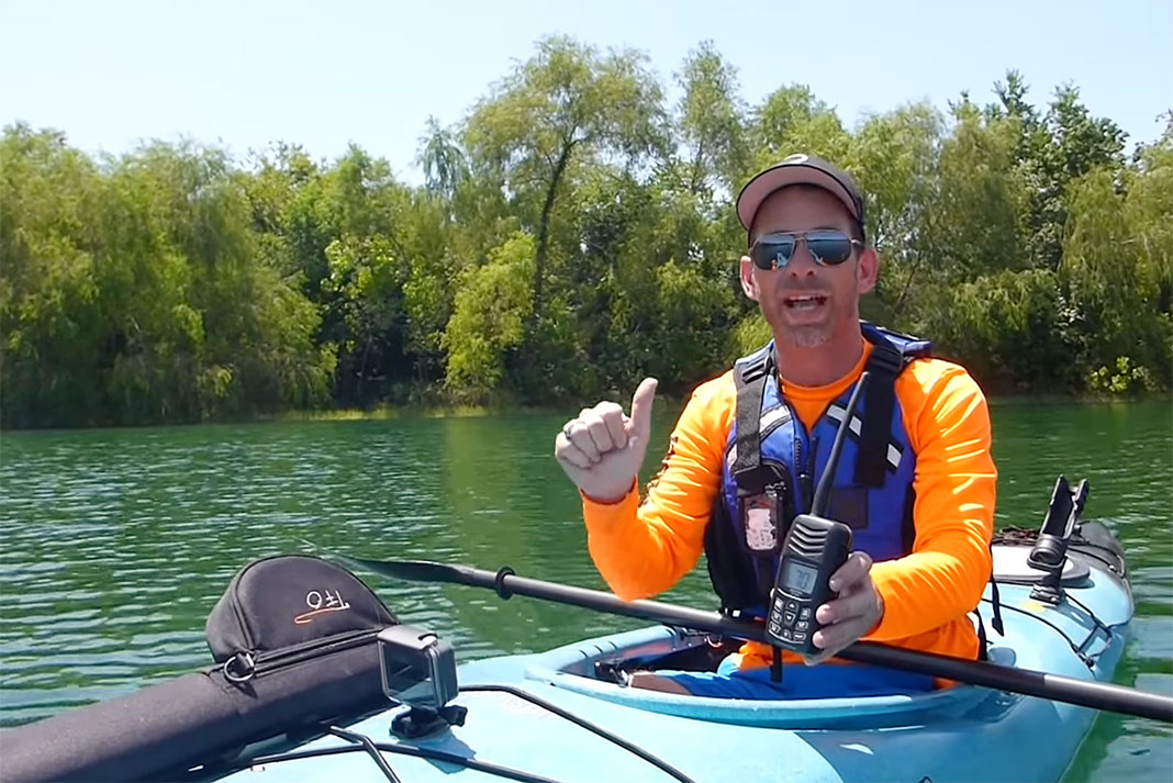 Jeff Herman holds up a VHF marine radio while in a kayak
