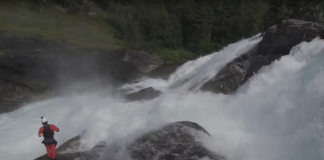 Kayaker scouts a big whitewater drop in norway