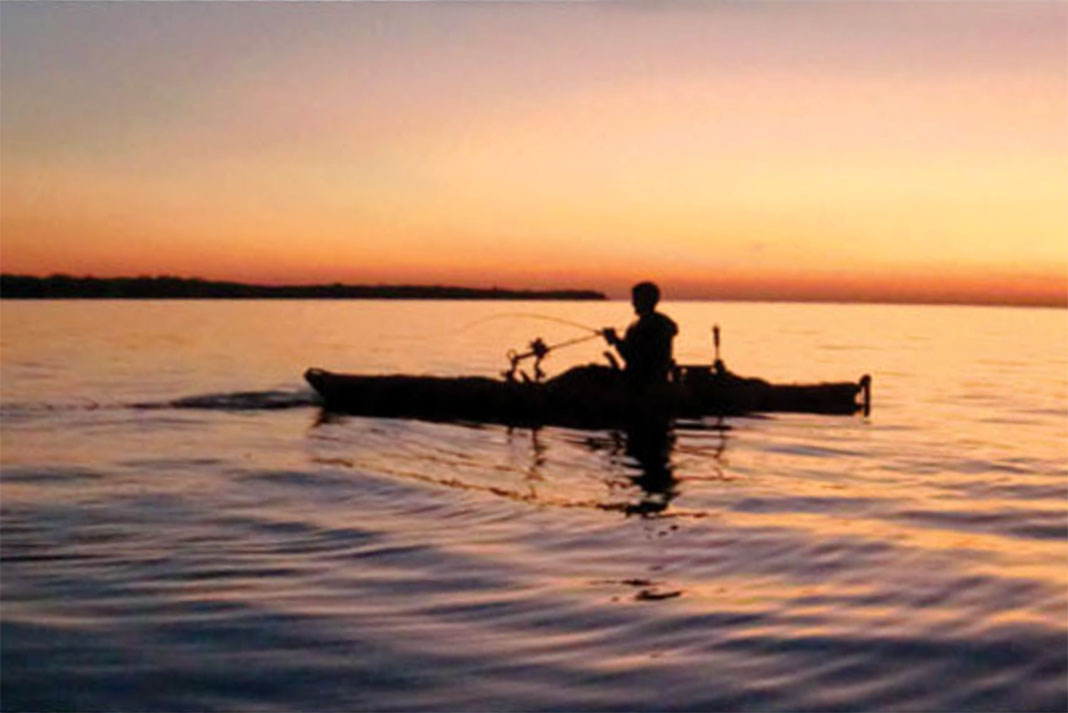 Lake Erie kayak angler silhouetted at sunset